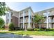 Three-story condo with brick and siding, showcasing multiple balconies, manicured landscaping, and inviting walkways at 18511 Harborside Dr, Cornelius, NC 28031