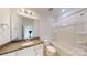 Bathroom with granite countertops, a large mirror and a tub with white tile surround at 2143 Barrowcliffe Nw Dr, Concord, NC 28027