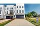 Modern townhouse with a dark garage door, concrete driveway, and well-maintained landscaping at 2143 Barrowcliffe Nw Dr, Concord, NC 28027