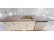Close-up of a kitchen island with granite countertop, stainless steel sink, and white cabinets at 2143 Barrowcliffe Nw Dr, Concord, NC 28027
