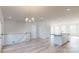 Open-concept living room with hardwood floors, modern light fixture, and a view of the kitchen at 2143 Barrowcliffe Nw Dr, Concord, NC 28027