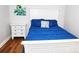 Bedroom featuring wood-look floors, white dresser, and bright blue comforter at 218 Blacksnake Rd, Stanley, NC 28164