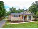Single-story home with well-manicured lawn, charming red shutters, and a cozy porch with seating at 218 Blacksnake Rd, Stanley, NC 28164