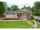 Charming single story home featuring a cozy front porch with rocking chairs and a well-maintained lawn at 218 Blacksnake Rd, Stanley, NC 28164