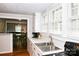 Well-lit kitchen featuring white cabinets, laminate floors, and a view of the adjacent dining and living rooms at 218 Blacksnake Rd, Stanley, NC 28164