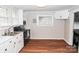 Compact kitchen with white cabinetry, laminate floors, and a view of the oven and available counter space at 218 Blacksnake Rd, Stanley, NC 28164
