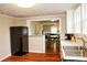 Kitchen with laminate floors, black appliances, and views into the living and dining areas at 218 Blacksnake Rd, Stanley, NC 28164