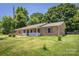 Charming brick home featuring a welcoming front porch and lush green lawn at 2526 Ashford Dr, Newton, NC 28658