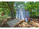Outdoor shed with ramp access, surrounded by mature trees and landscaping in backyard at 2526 Ashford Dr, Newton, NC 28658