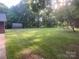 Large grassy backyard with mature trees and an outbuilding in the background at 4050 Rollingwood Cir, Rock Hill, SC 29732