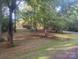 Single-story home in the background with a large grassy yard and mature trees at 4050 Rollingwood Cir, Rock Hill, SC 29732