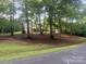 A single-story home is nestled among large trees in a large grassy yard at 4050 Rollingwood Cir, Rock Hill, SC 29732