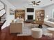 Cozy living room featuring a fireplace, built-in shelving, hardwood floors and modern furnishings at 5013 Crandon Rd, Fort Mill, SC 29707