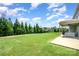 Lush green backyard with well-manicured lawn, mature trees, and covered patio at 5079 Nighthawk Dr, Fort Mill, SC 29707