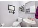 Chic powder room with pedestal sink, decorative mirror, and modern fixtures at 5079 Nighthawk Dr, Fort Mill, SC 29707