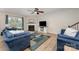 Bright living room with a cozy fireplace, ceiling fan, and plush blue furnishings at 5079 Nighthawk Dr, Fort Mill, SC 29707