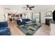 Open-concept living room flows into the kitchen, with hardwood floors, ceiling fan, fireplace, and blue couches at 5079 Nighthawk Dr, Fort Mill, SC 29707