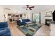 Open-concept living room flows into the kitchen, with hardwood floors, ceiling fan, fireplace, and blue couches at 5079 Nighthawk Dr, Fort Mill, SC 29707