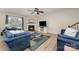 Bright living room with a cozy fireplace, ceiling fan, and plush blue furnishings at 5079 Nighthawk Dr, Fort Mill, SC 29707