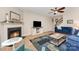 Comfortable living room features a fireplace, neutral walls, ceiling fan, and stairs to 2nd level at 5079 Nighthawk Dr, Fort Mill, SC 29707
