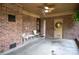 Spacious covered porch with brick walls, ceiling fan, and outdoor seating area at 5329 E Highway 27 Hwy, Iron Station, NC 28080