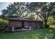 Backyard view of a charming brick home with a well-manicured lawn and established plantings at 5329 E Highway 27 Hwy, Iron Station, NC 28080