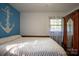 Bright bedroom with a neutral color scheme and a large anchor decal on the blue accent wall at 5329 E Highway 27 Hwy, Iron Station, NC 28080