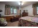 Comfortable bedroom featuring floral bedding, wood paneling, and classic furnishings at 5329 E Highway 27 Hwy, Iron Station, NC 28080