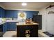 Bright kitchen with blue cabinets, granite countertops, a kitchen island, and stainless steel appliances at 5329 E Highway 27 Hwy, Iron Station, NC 28080