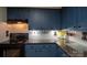 Kitchen featuring blue cabinets, granite countertops, white subway tile backsplash, and stainless steel appliances at 5329 E Highway 27 Hwy, Iron Station, NC 28080