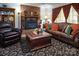 Inviting living room featuring a brick fireplace, plush leather seating, and patterned area rug at 5329 E Highway 27 Hwy, Iron Station, NC 28080