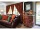 Cozy living room featuring a comfortable leather couch, ornate curtains, and stylish decor at 5329 E Highway 27 Hwy, Iron Station, NC 28080