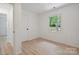 Bright and airy bedroom featuring hardwood floors and a window overlooking lush greenery at 5420 Gwynne Ave # 21, Charlotte, NC 28205
