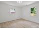 A bright bedroom featuring light wood flooring and two windows looking out onto a grassy back yard at 5420 Gwynne Ave # 21, Charlotte, NC 28205