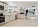 Bright, spacious kitchen featuring white cabinetry, stainless appliances, and an adjacent living area at 5420 Gwynne Ave # 21, Charlotte, NC 28205