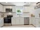 Updated kitchen features white cabinetry, stainless steel appliances, and a stylish backsplash at 5420 Gwynne Ave # 21, Charlotte, NC 28205