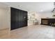Bright living room featuring hardwood floors, a sleek accent wall, and an open view to a modern kitchen at 5420 Gwynne Ave # 21, Charlotte, NC 28205