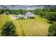 Areal view of backyard, detached garage, sprawling lawn, and mature trees enhance this beautiful home's appeal at 594 Patterson Farm Rd, Mooresville, NC 28115