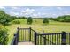 Scenic view of a lush, green backyard with rolling hills and mature trees from a wooden deck with black metal railings at 594 Patterson Farm Rd, Mooresville, NC 28115