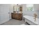 Charming bathroom features a standalone tub, wood vanity, and penny tile flooring for a spa-like experience at 594 Patterson Farm Rd, Mooresville, NC 28115