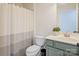 Well-lit bathroom featuring a white and striped shower curtain, sink, and toilet at 594 Patterson Farm Rd, Mooresville, NC 28115