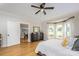 Light-filled bedroom featuring hardwood floors, bay window, and a glimpse into an adjacent dining area at 594 Patterson Farm Rd, Mooresville, NC 28115