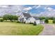 Expansive lawn and exterior view of a two-story home, complemented by lush landscaping and a detached garage at 594 Patterson Farm Rd, Mooresville, NC 28115