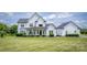 Charming two-story home with a covered front porch, manicured lawn, and lush landscaping at 594 Patterson Farm Rd, Mooresville, NC 28115