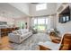 Open living room with a large window overlooking a green lawn, plush grey sofa, and modern decor at 594 Patterson Farm Rd, Mooresville, NC 28115
