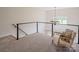 Inviting loft area with a comfortable chair, stylish railing, and natural light creating a peaceful retreat at 594 Patterson Farm Rd, Mooresville, NC 28115