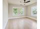 Bright bedroom featuring hardwood floors, two large windows, and a modern ceiling fan at 616 W Marion St, Shelby, NC 28150