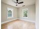 Bright bedroom featuring hardwood floors, two large windows, and a modern ceiling fan at 616 W Marion St, Shelby, NC 28150