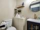 Half bathroom with floating shelves, round mirror, black vanity with gold hardware at 616 W Marion St, Shelby, NC 28150