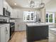 The kitchen features white cabinets, stainless appliances, gold hardware, and a marble countertop island at 616 W Marion St, Shelby, NC 28150